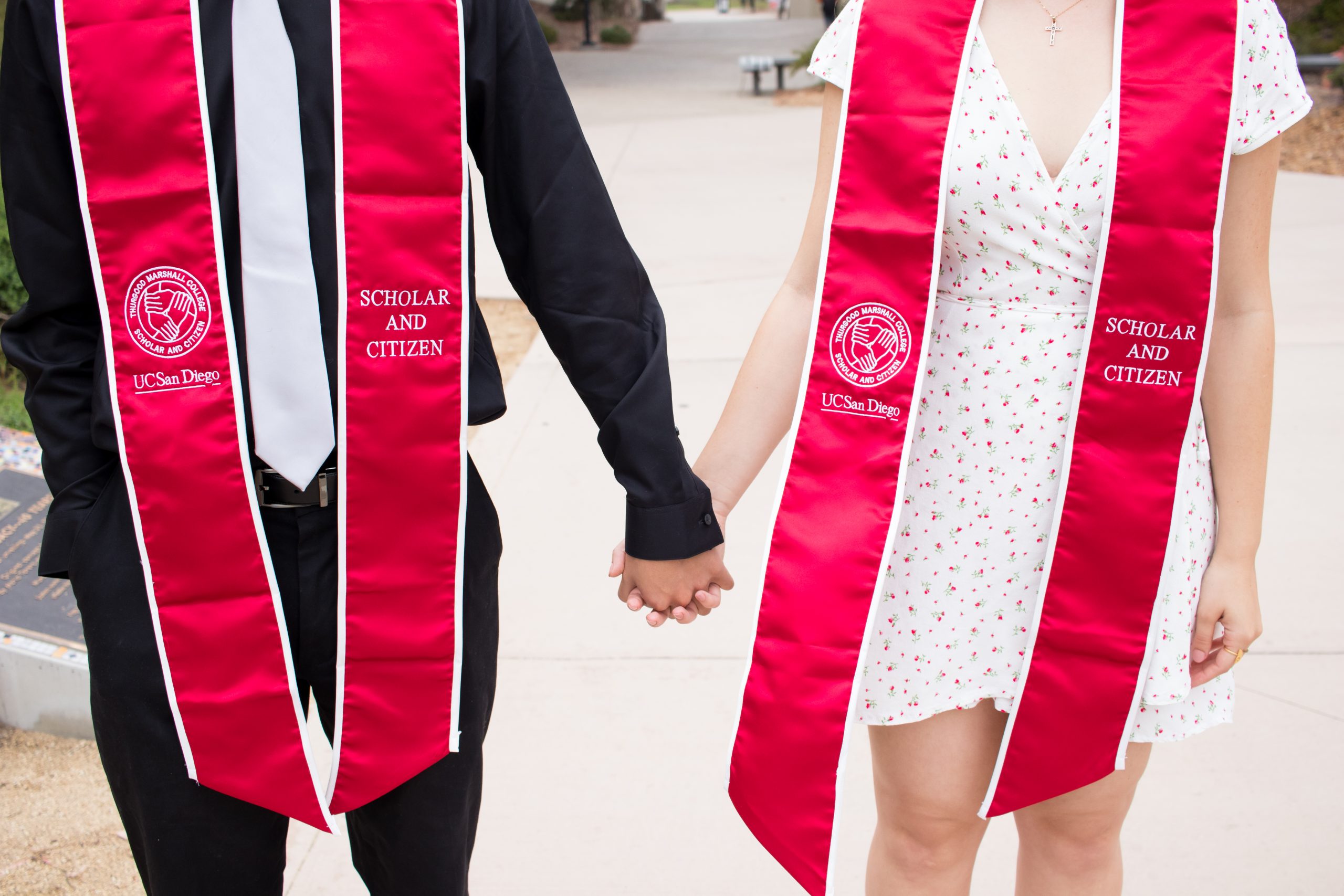 Two students wearing matching graduation stoles 